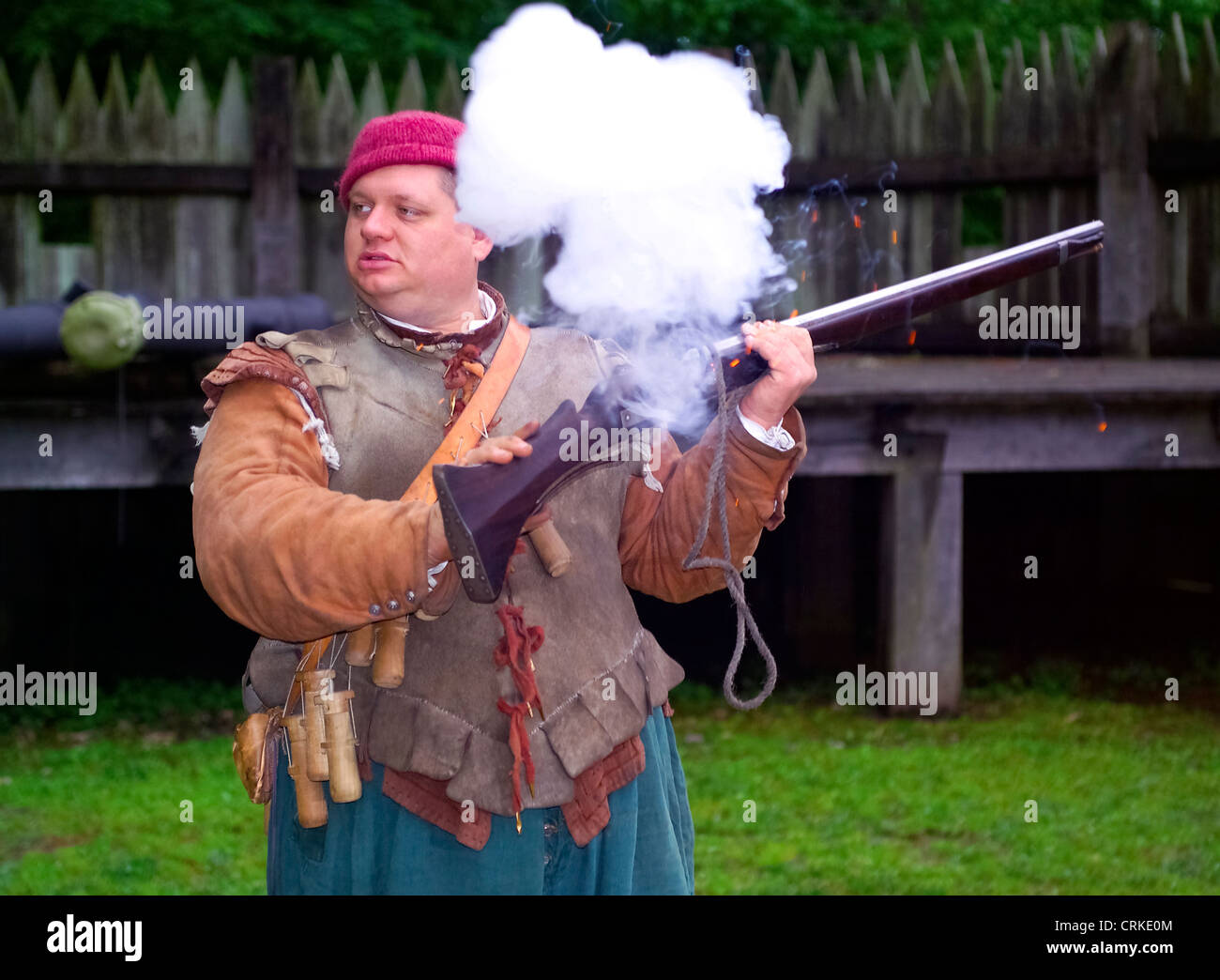 A historical interpreter fires a matchlock musket after demonstrating how to load the weapon with gunpowder at Jamestown Settlement in Virginia, USA. Stock Photo