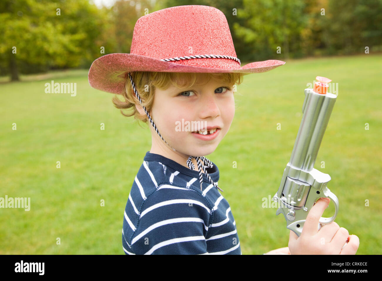 Boy playing with toy gun outdoors Stock Photo