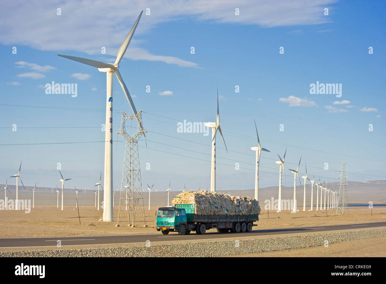 A truck travelling along the G30 Lianhuo expressway with part of the Daheyan wind farm in the background. Stock Photo