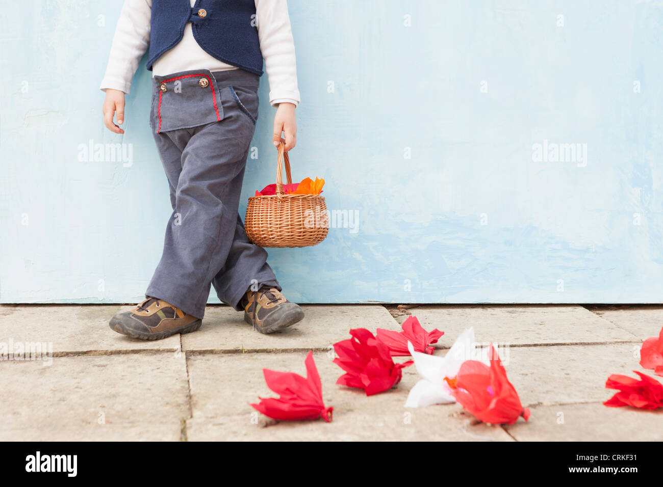 Boy holding basket of paper flowers Stock Photo