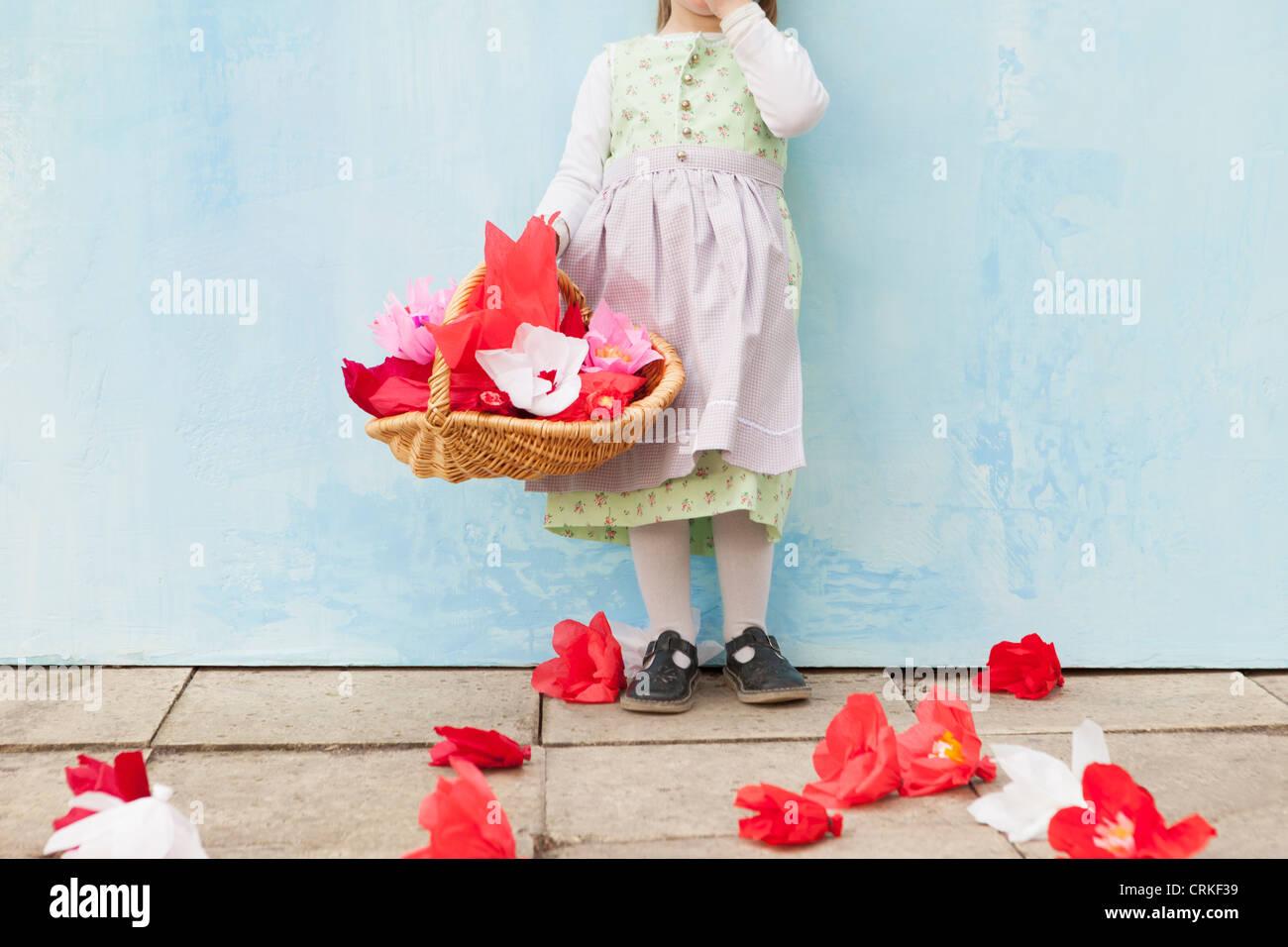 Girl holding basket of paper flowers Stock Photo