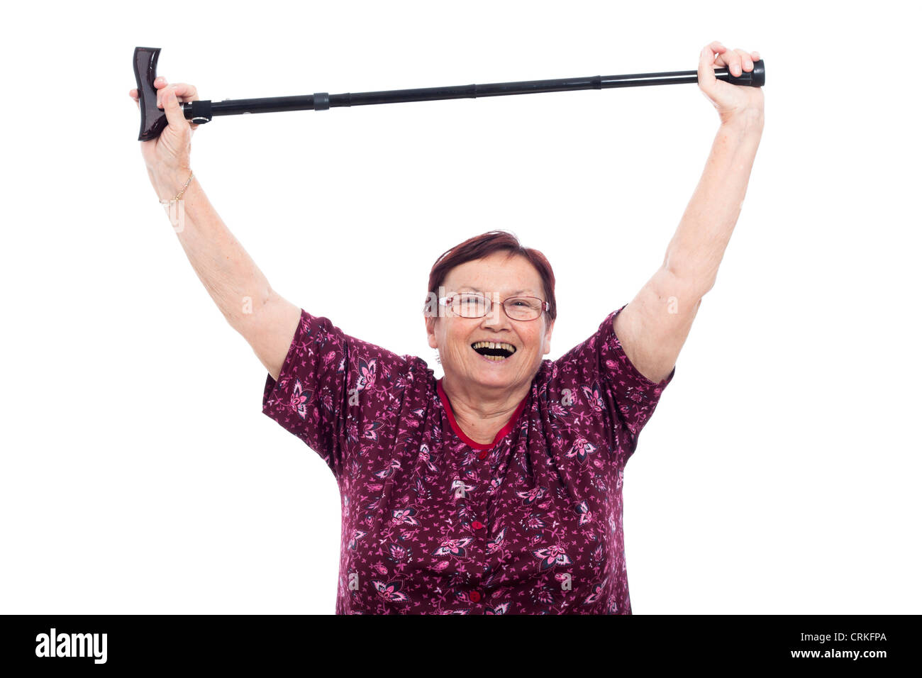 Happy laughing elderly woman holding walking stick, isolated on white background. Stock Photo
