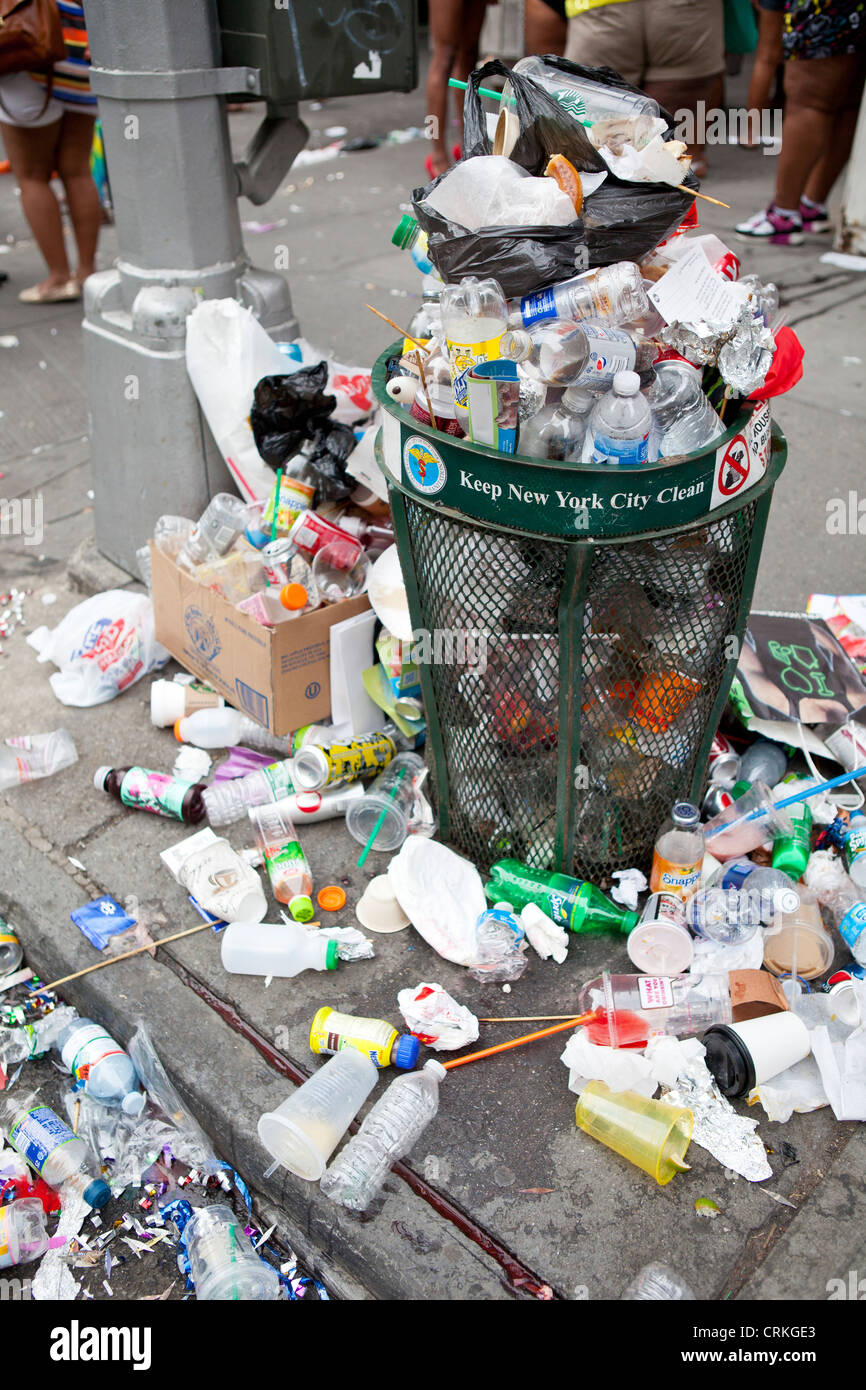 Big two metal dumpster garbage cans full of overflow litter and junk  polluting the street in the city Stock Photo