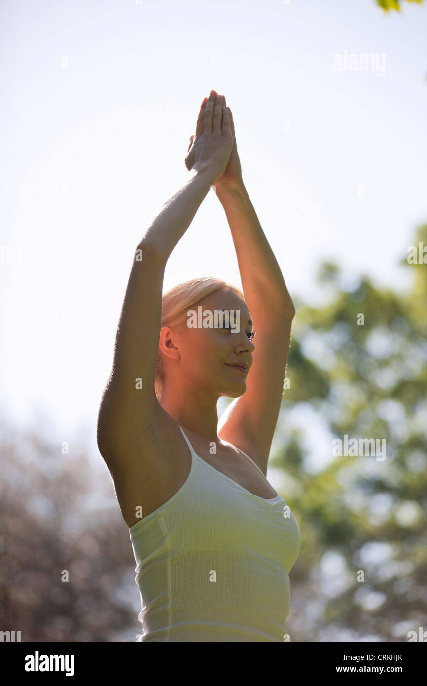 A young woman practicing yoga outside, standing in tree pose Stock ...