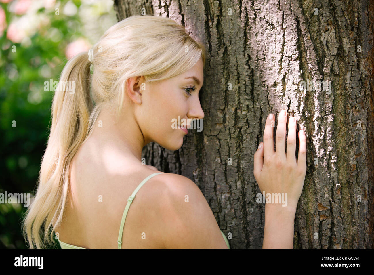Female leaning against tree hi-res stock photography and images - Alamy