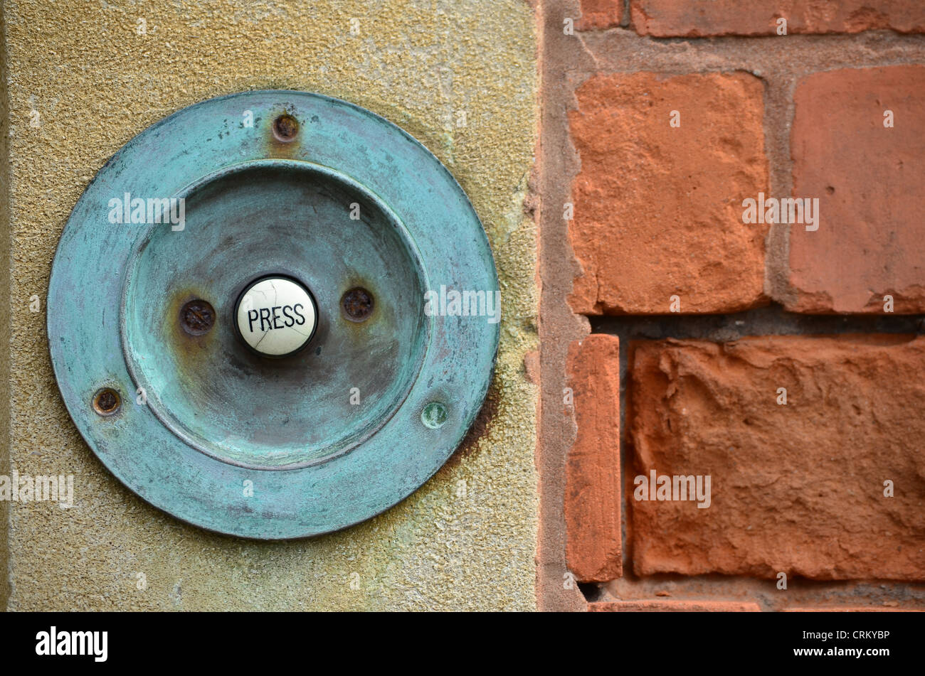 Victorian doorbell with the wording 'press' mounted into a masonry and brick wall Stock Photo