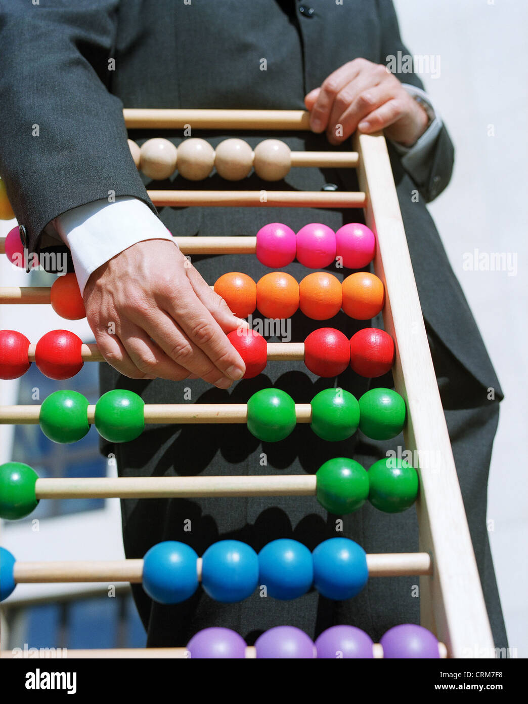 Man in a dark suit moved balls on an abacus Stock Photo