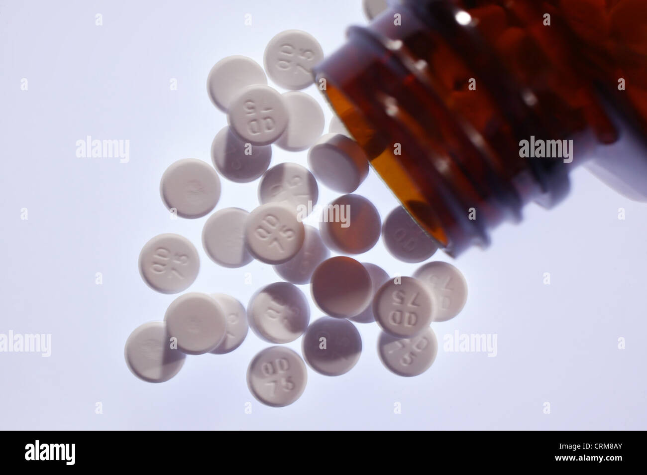 White paracetamol tablets spilling out of a brown bottle. Stock Photo