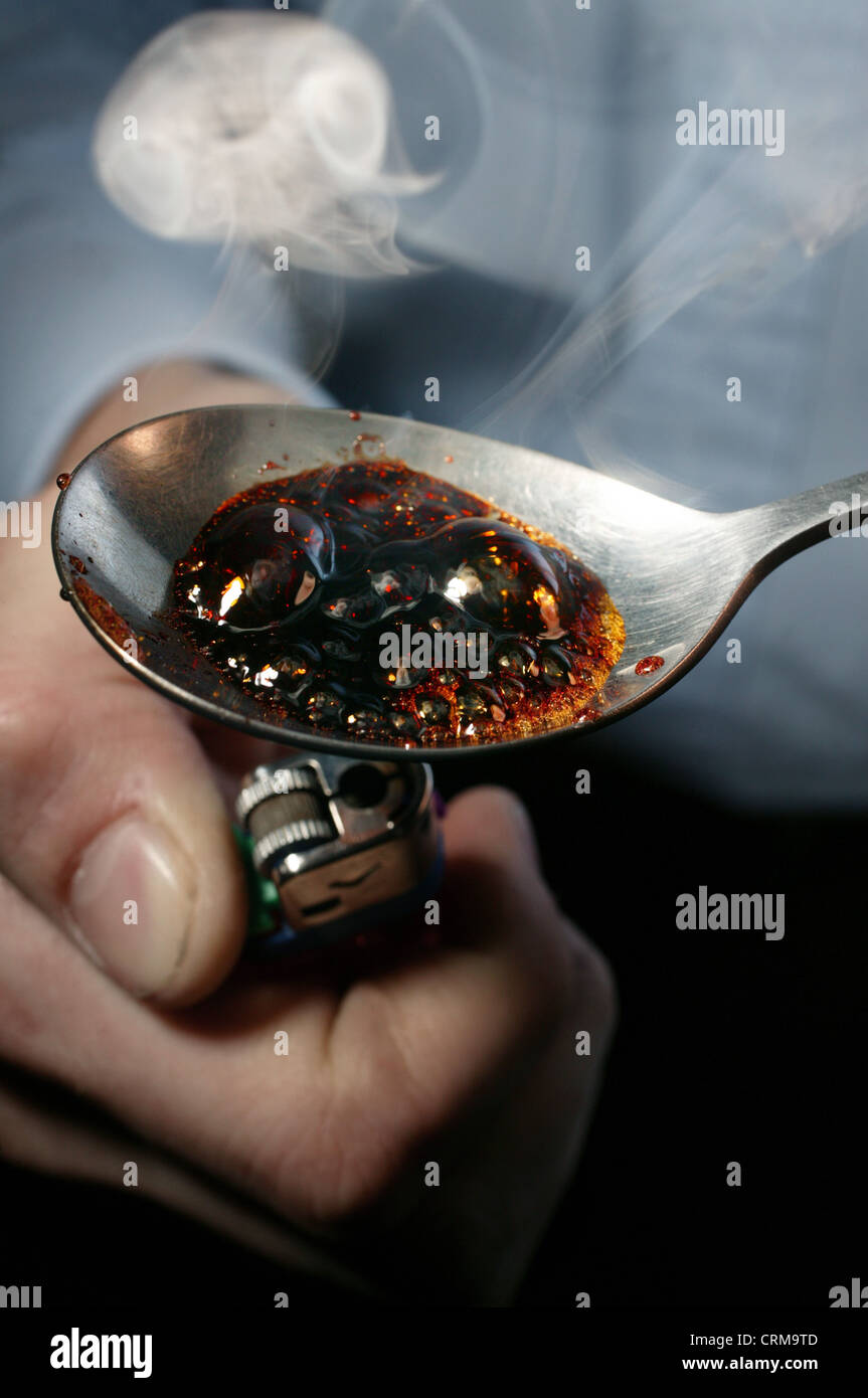 man cooking up drugs on a spoon with a lighter Stock Photo Alamy