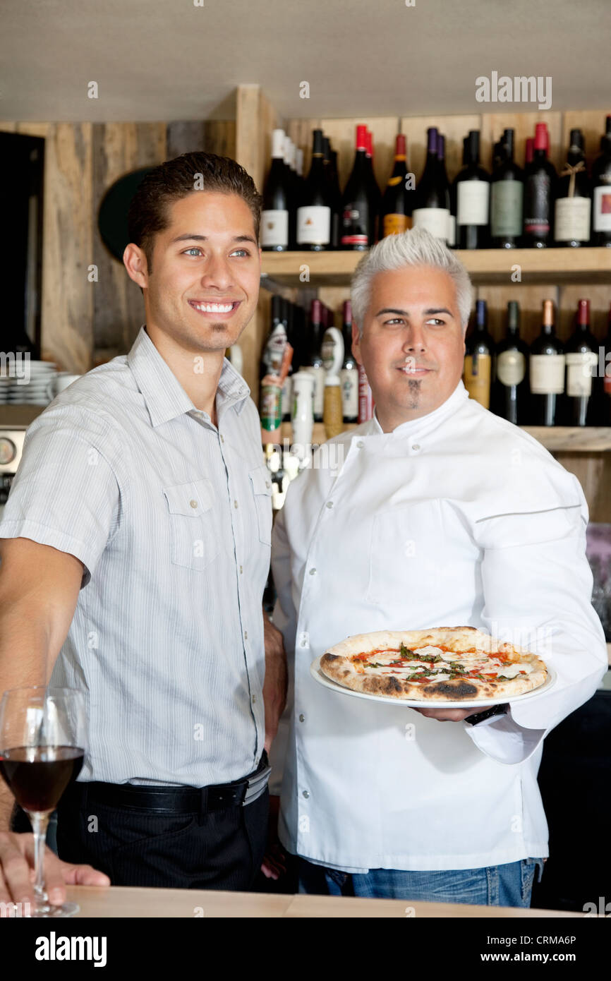 Happy men with wine glass and pizza looking away Stock Photo