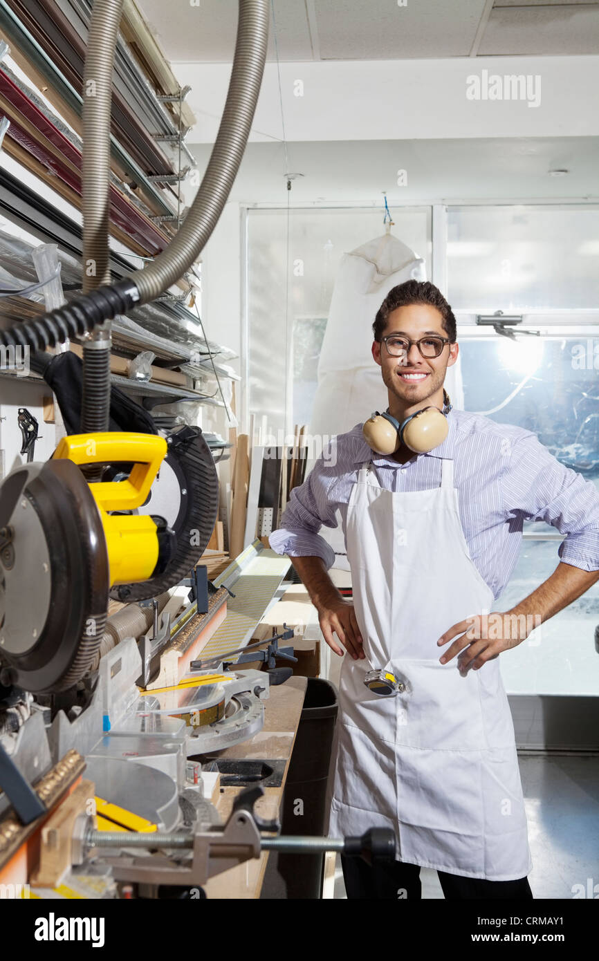Portrait of a skilled worker standing with hands on hips in workshop Stock Photo