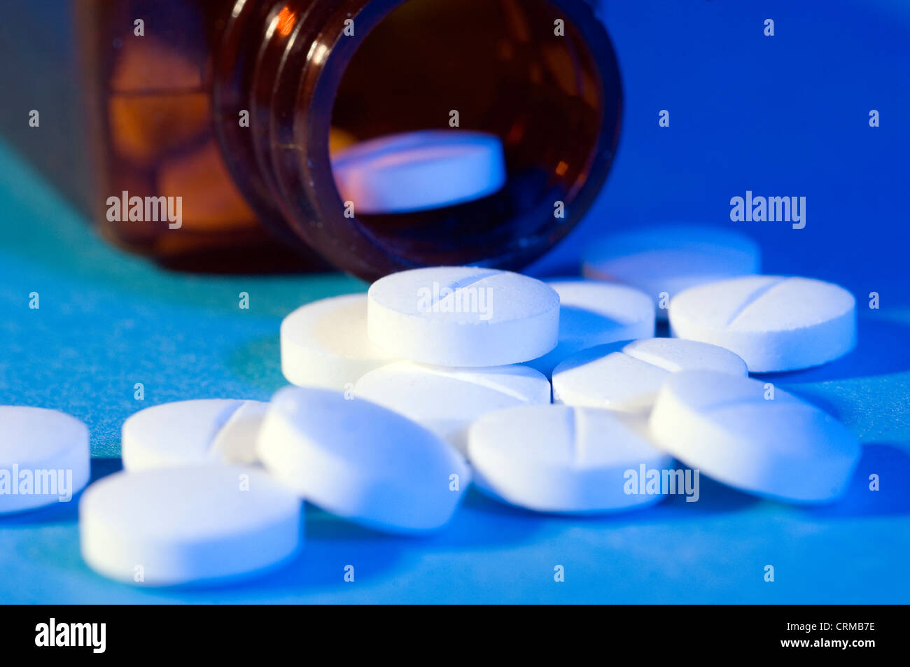 White pills spilling from a medicine bottle. Stock Photo