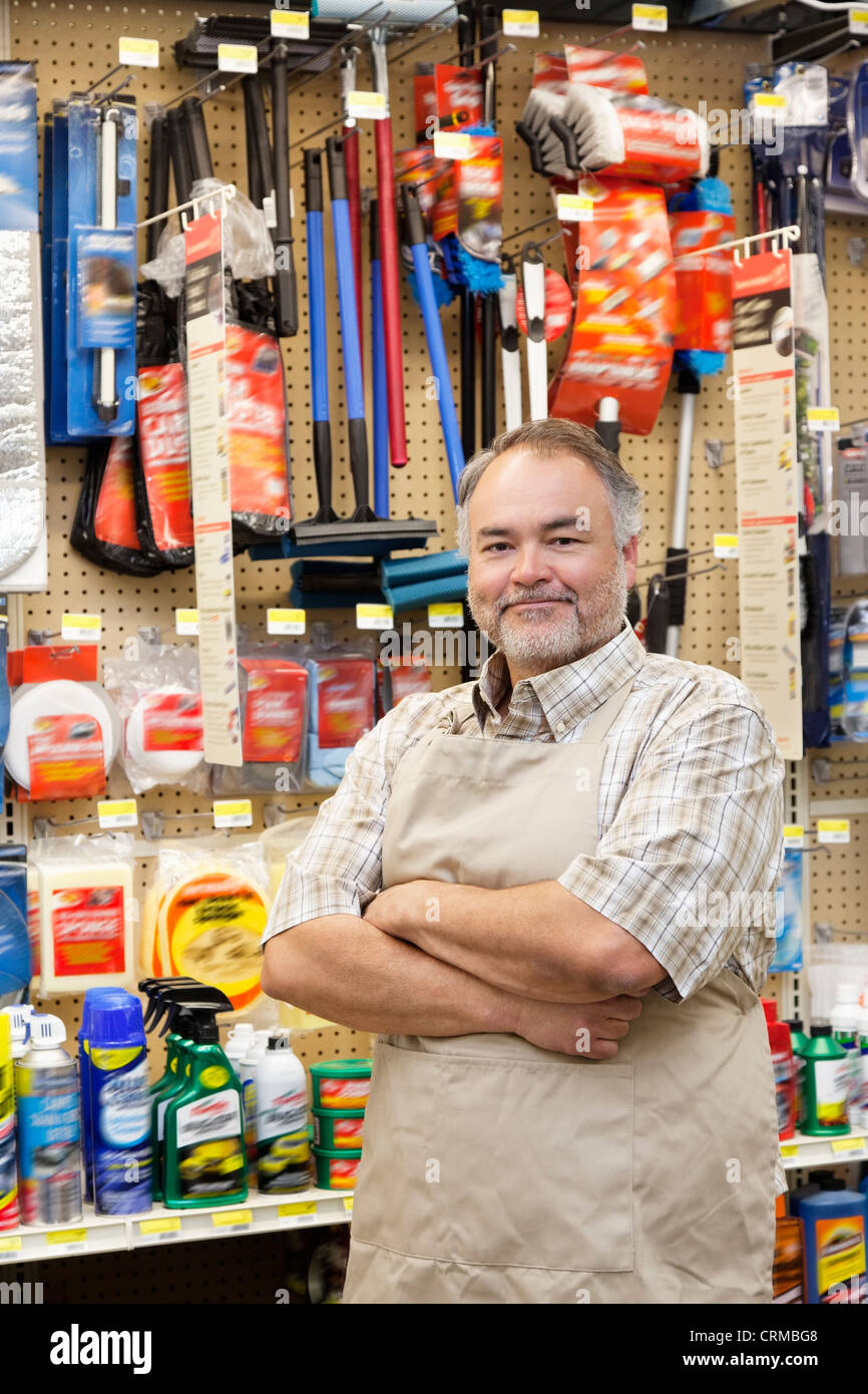 Portrait of a confident mature salesperson with arms crossed in hardware store Stock Photo