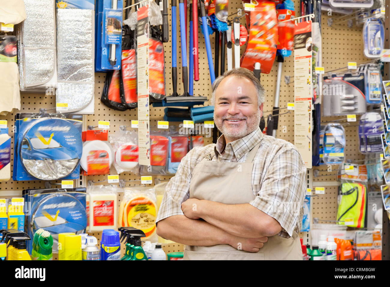 Portrait of a happy mature salesperson with arms crossed in hardware store Stock Photo