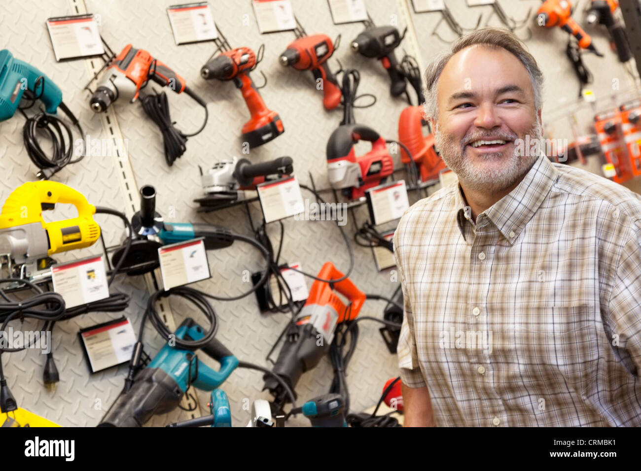 Happy mature hardware store owner looking away Stock Photo Alamy