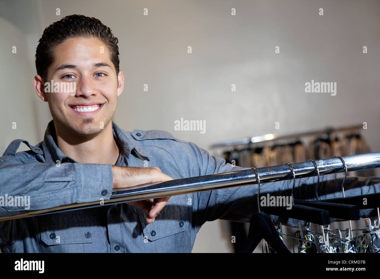 Portrait of a happy young man standing in fashion boutique Stock Photo ...