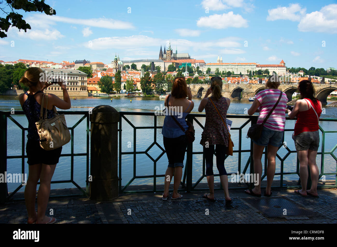 Tourists at Vltava river bank looking and photographing Saint Vitus's Cathedral Prague Castle Czech Republic Stock Photo