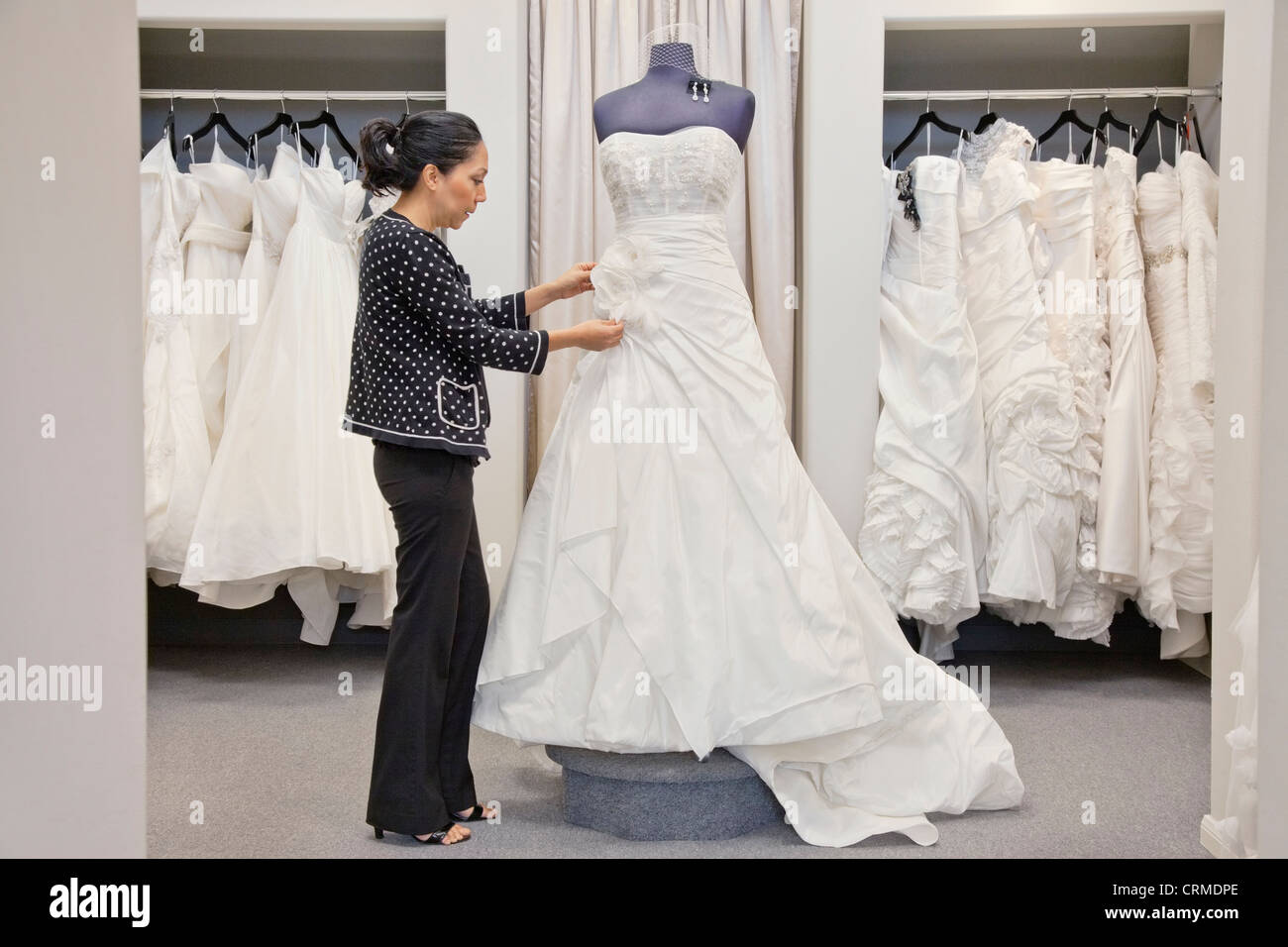 Side View Of A Mature Employee Adjusting Elegant Wedding Dress In