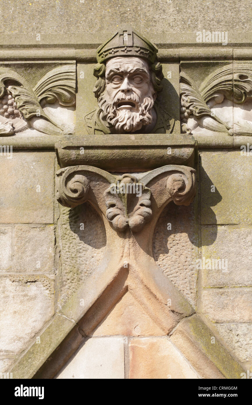 Head carved in stone on the façade of St Mungo's Roman Catholic church, Parson Street, Townhead, Glasgow, Scotland, UK Stock Photo