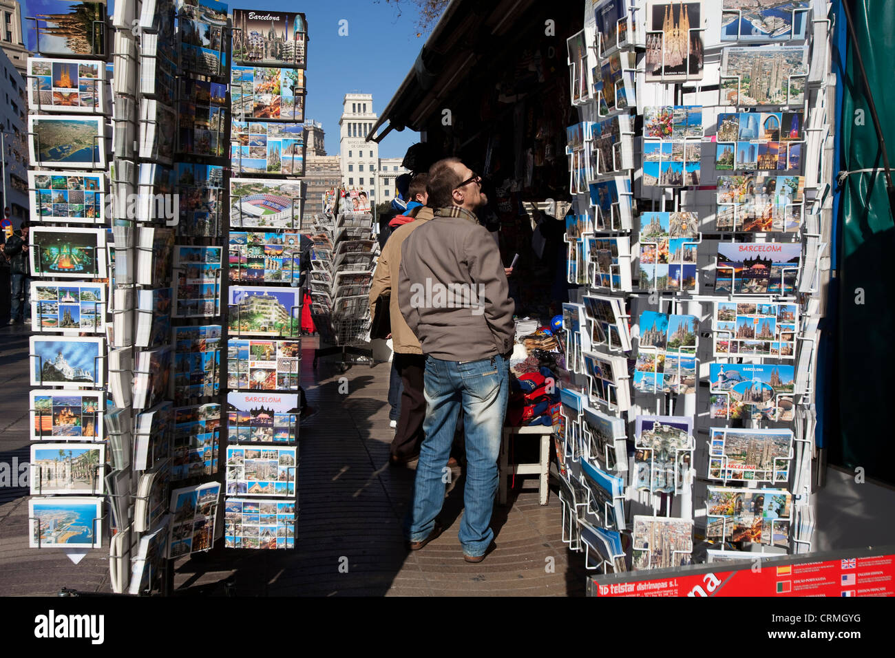 Men watching postcards of a newspaper kiosk in Las Ramblas of Barcelona Stock Photo