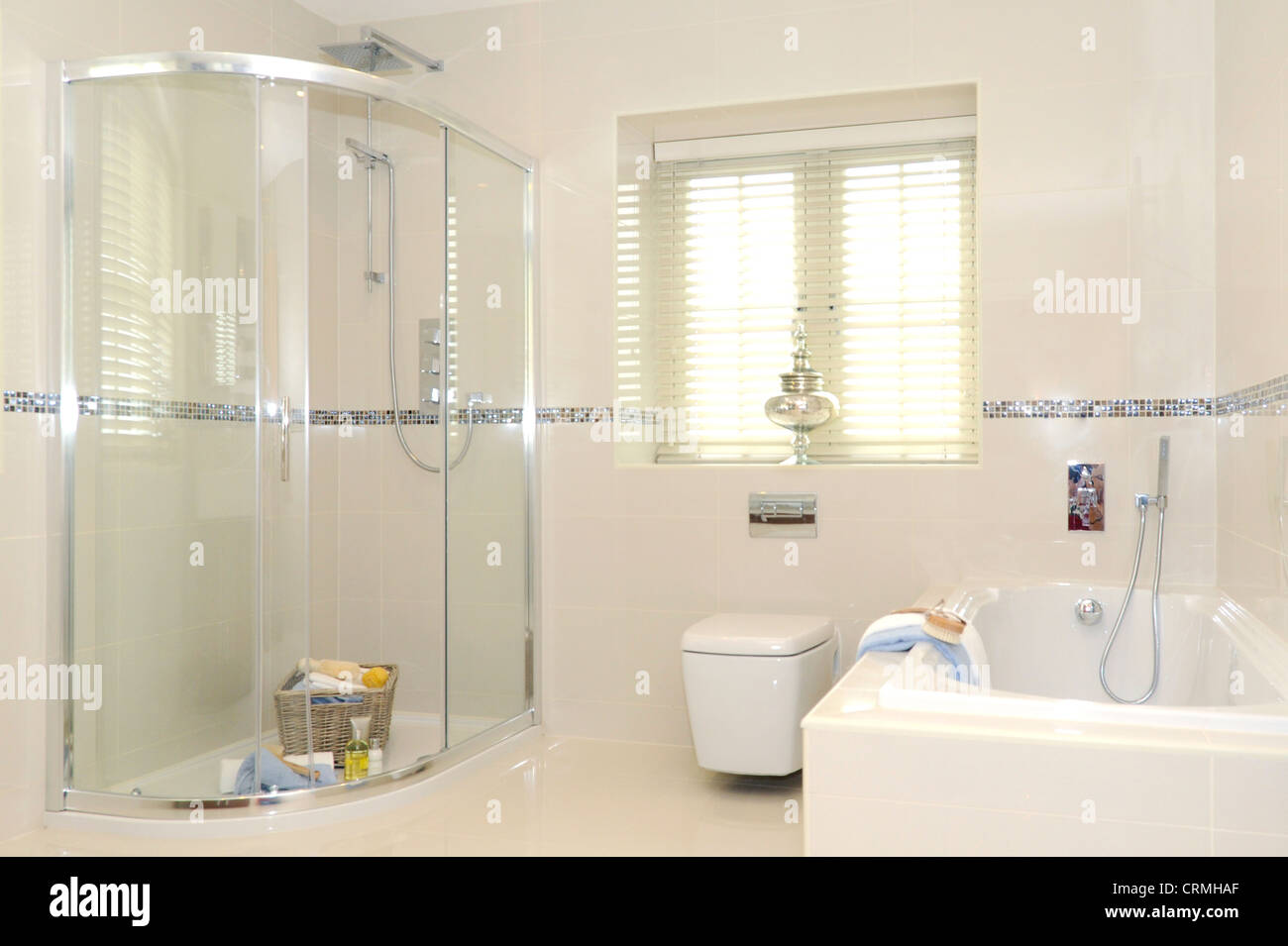 a quality bathroom including shower and enclosure, toilet and bath, with white tile decoration Stock Photo