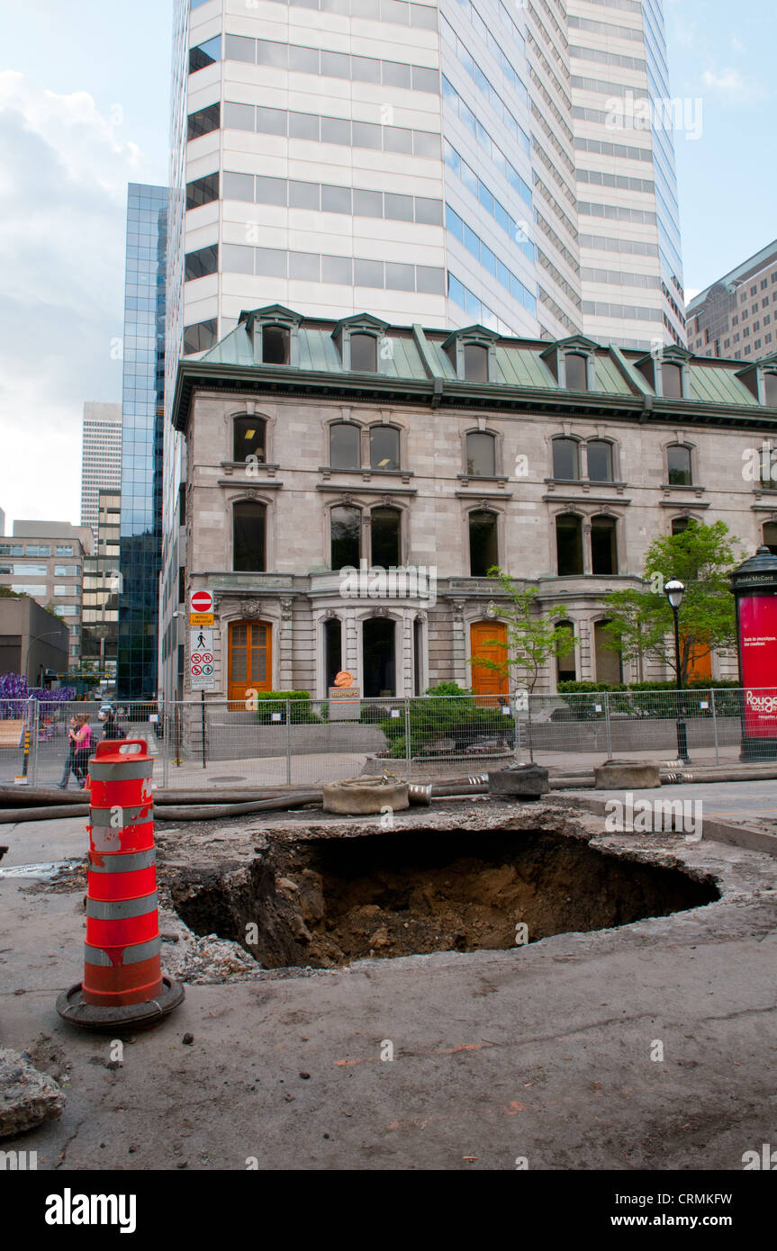 This huge sinkhole of four meter diameter & six meters deep hole appeared in downtown Montreal in may 2012 following heavy rains Stock Photo