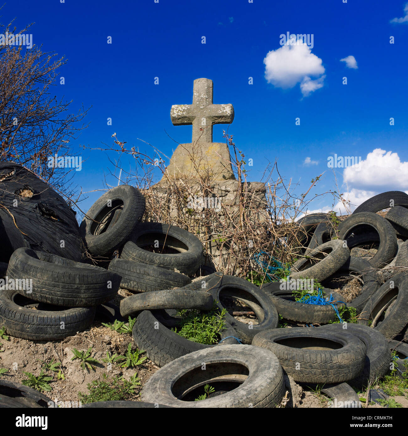 Stone cross and heap of discarded tires, Auvergne-rhone-Alpes, France Stock Photo