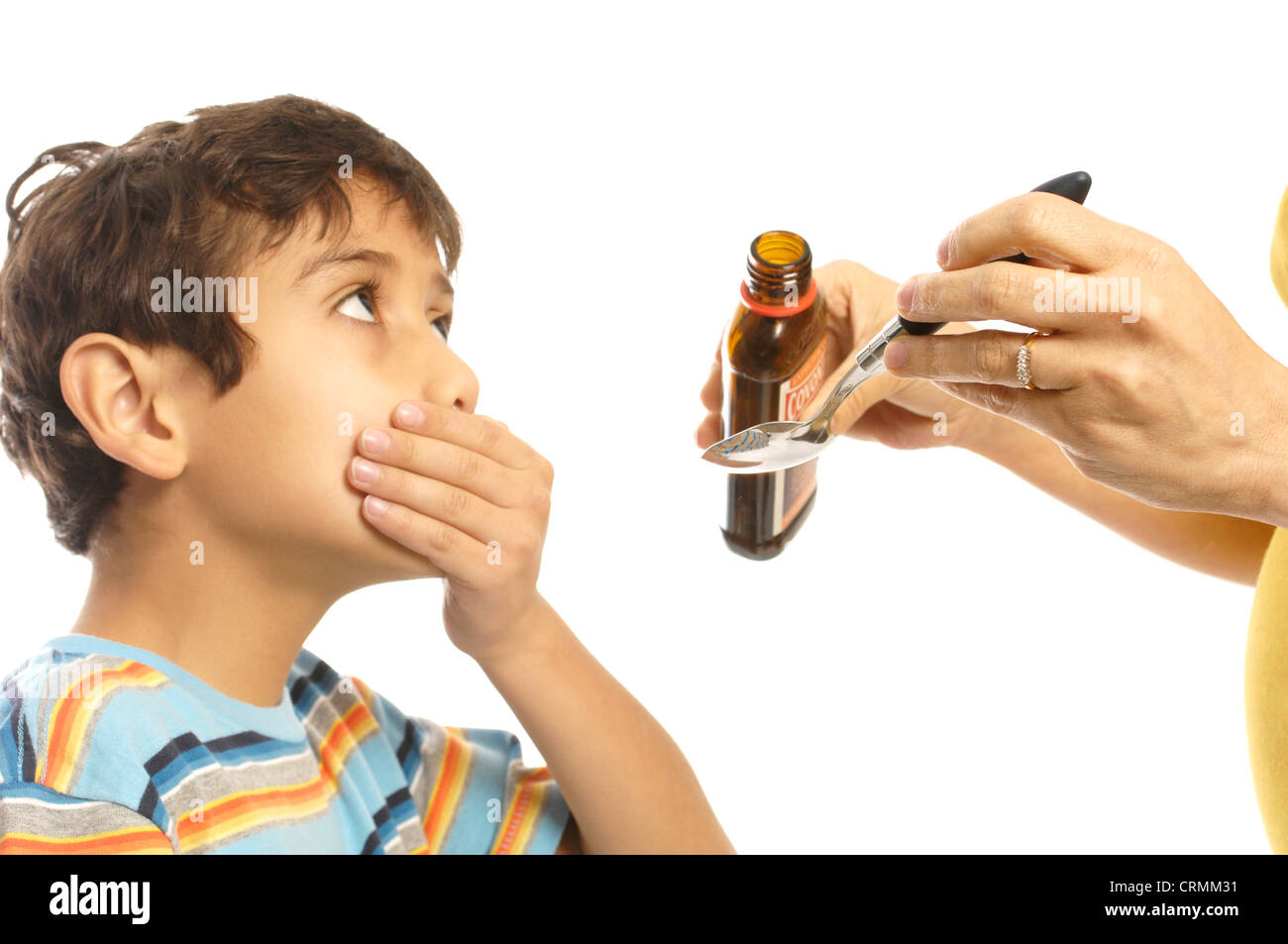 A young boy refusing to take cough syrup from his mother Stock Photo