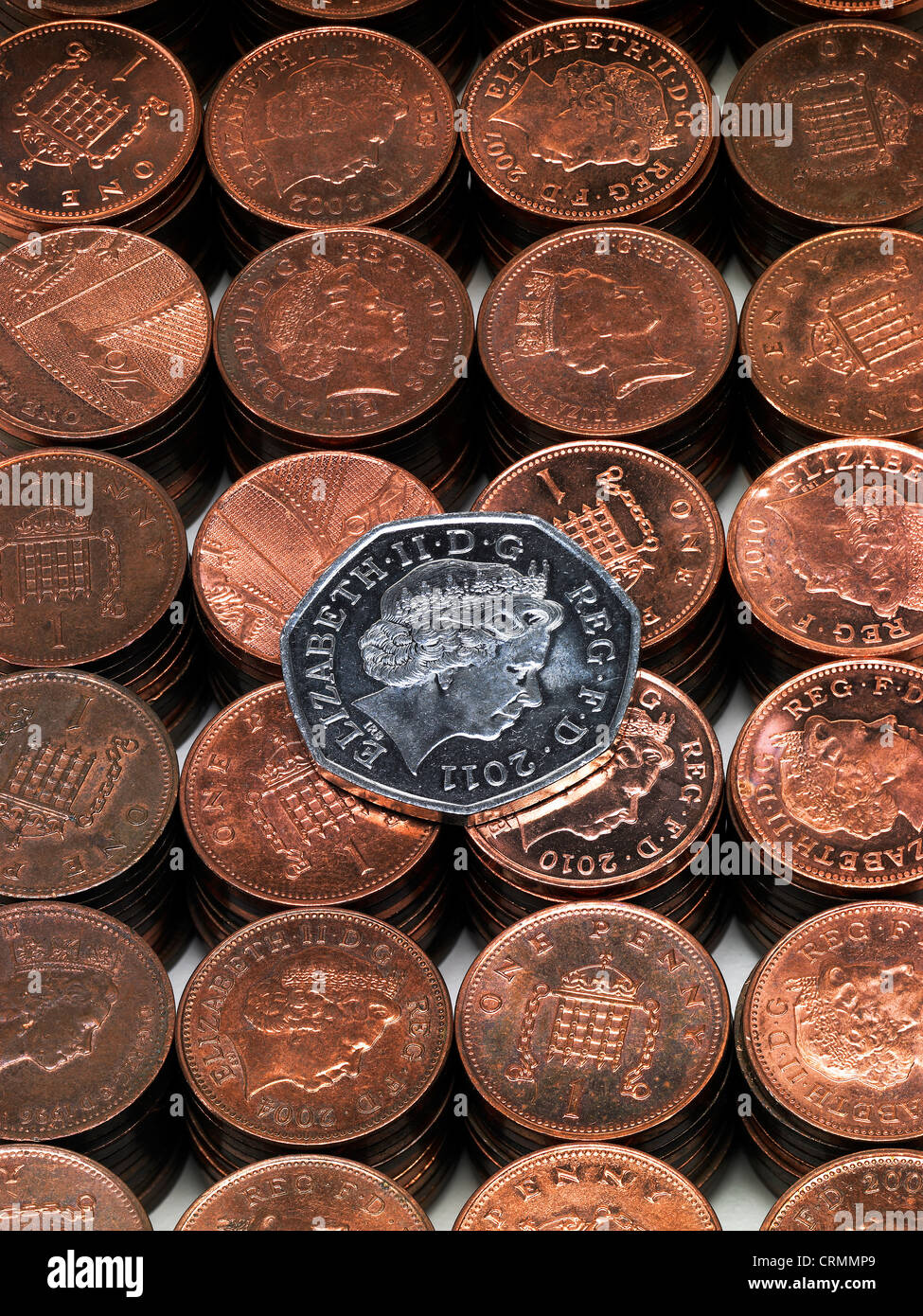 Neat piles of British pennies with a fifty pence piece Stock Photo