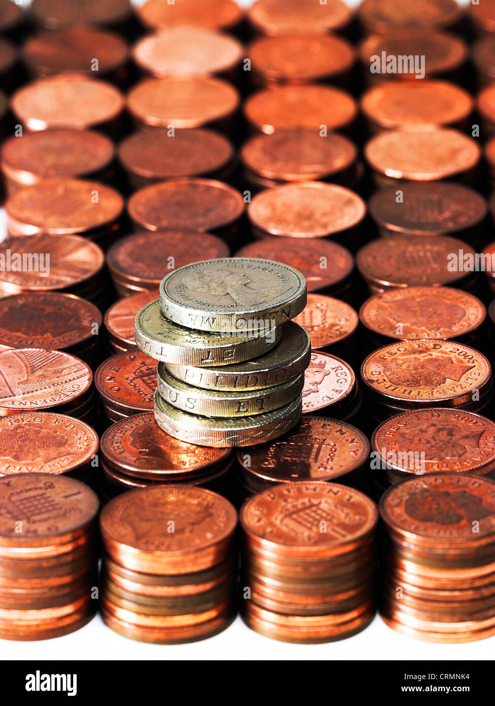 Neat piles of British pennies with a pile of one pound coins Stock Photo