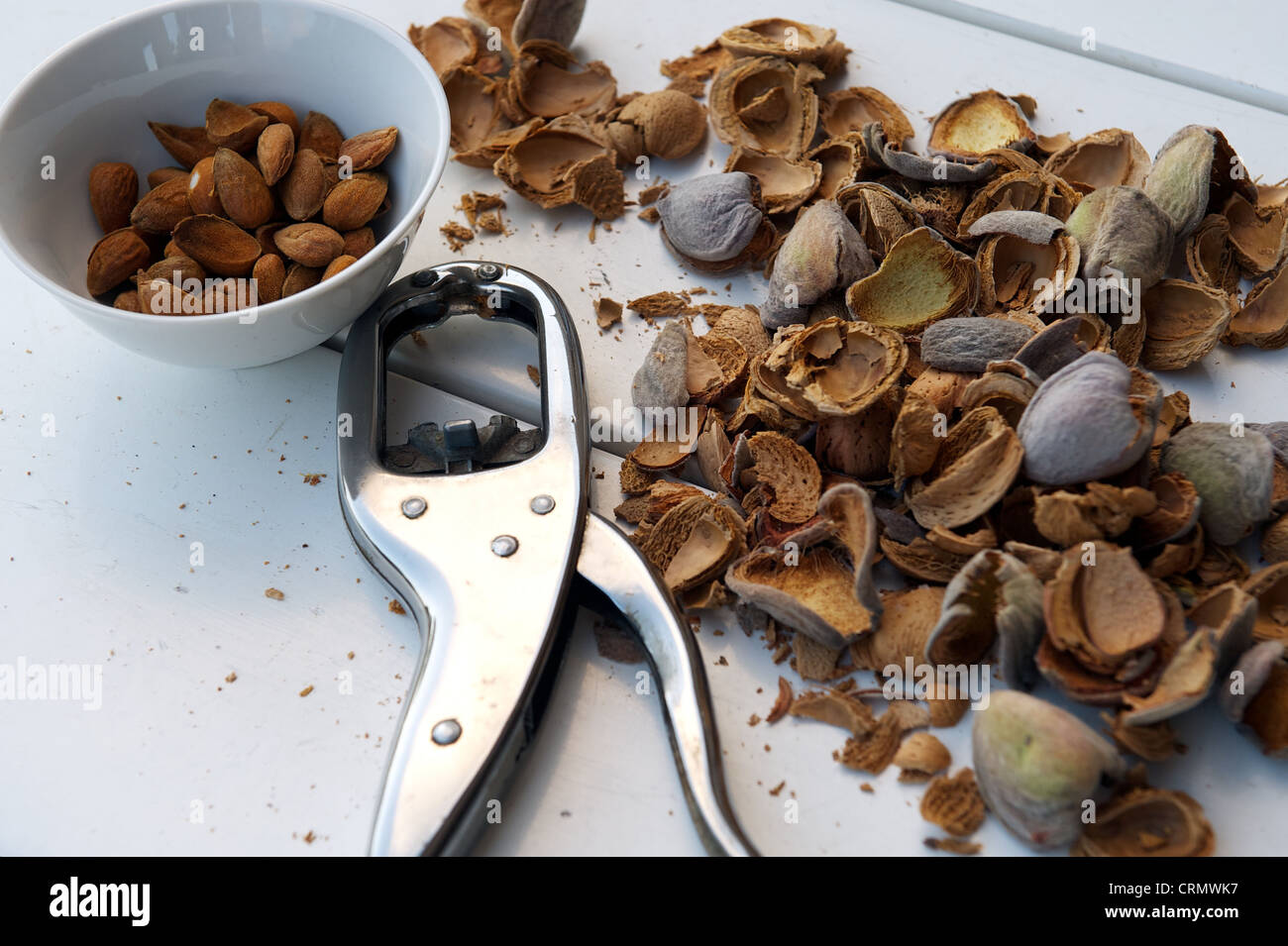 Shelled almonds in their brown skin with a nutcracker and the discarded ...