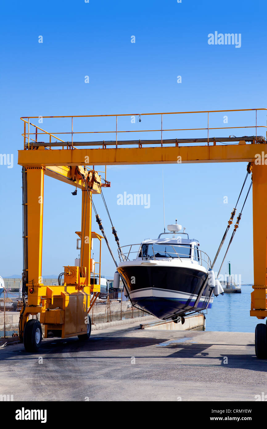 crane travelift lifting a boat on blue sky day in balearic islands Stock Photo