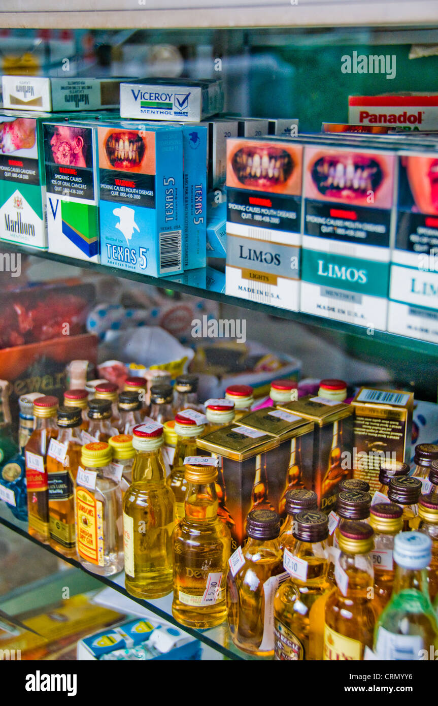 morbid graphic cigarette packages and small liquor bottles at convenience store in Singapore Stock Photo