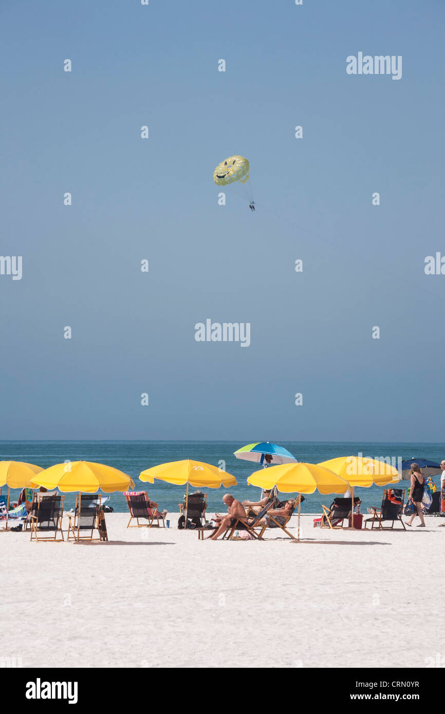 Yellow umbrella parasailing and sunbathers, Clearwater beach, FL Stock