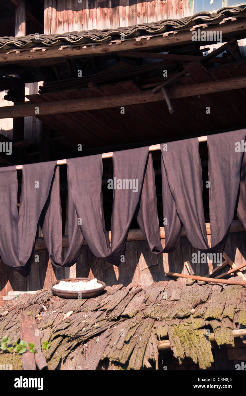Indigo dyed fabric hanging to dry in the sun - Dong village of Zhaoxing, Guizhou province - China Stock Photo