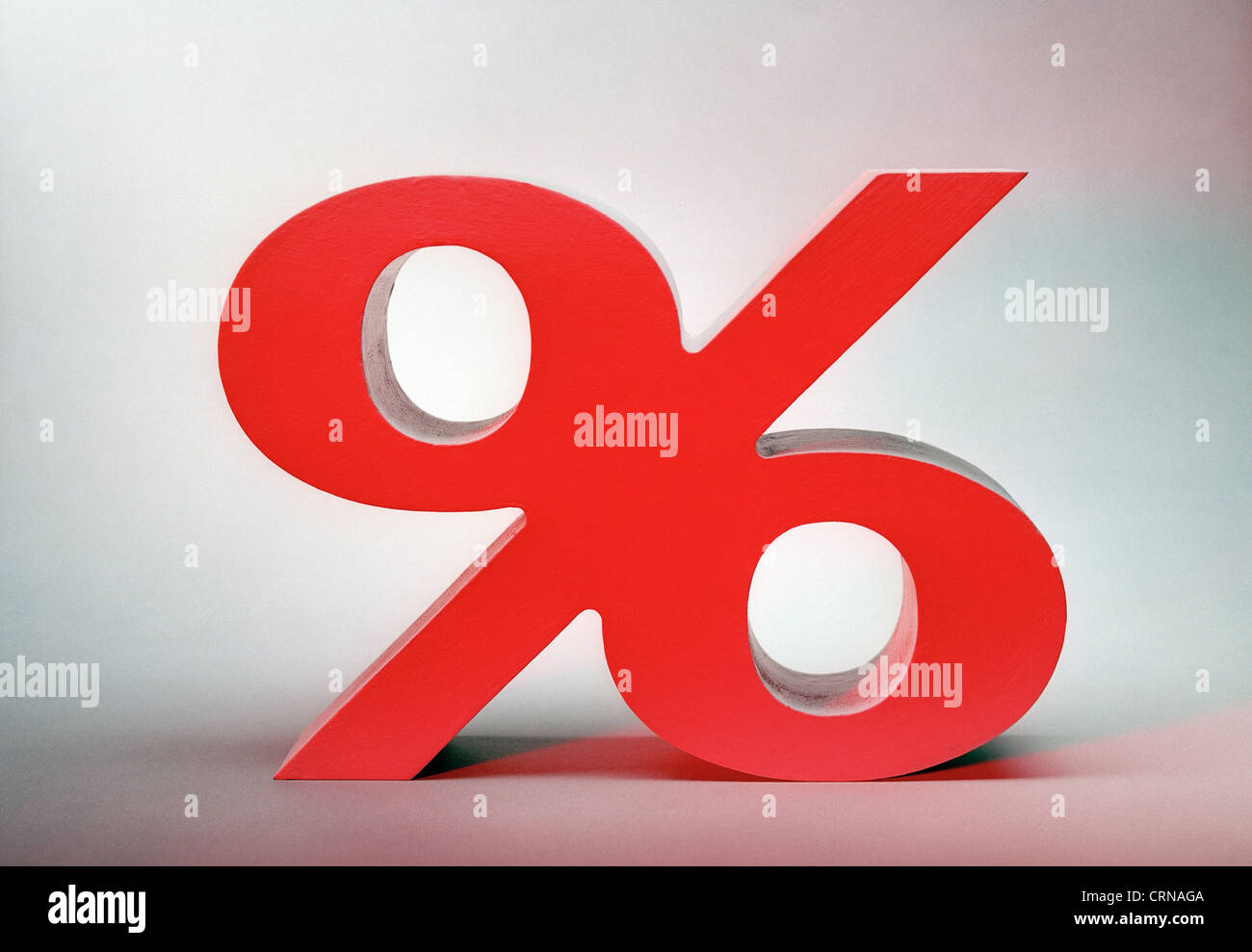 An illuminated red percent sign before a light background Stock Photo