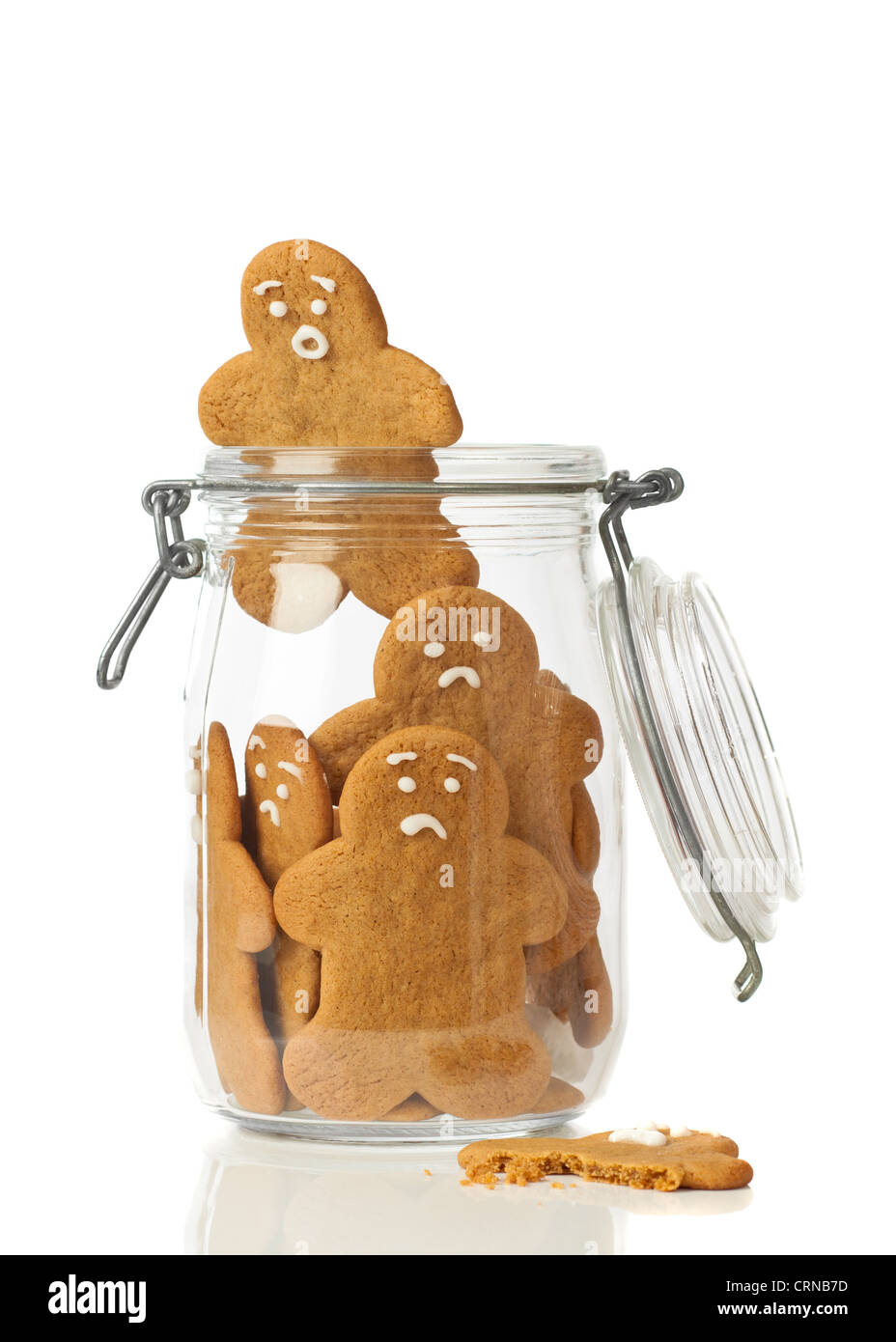 Gingerbread man escaping the jar of cookies on white background Stock Photo