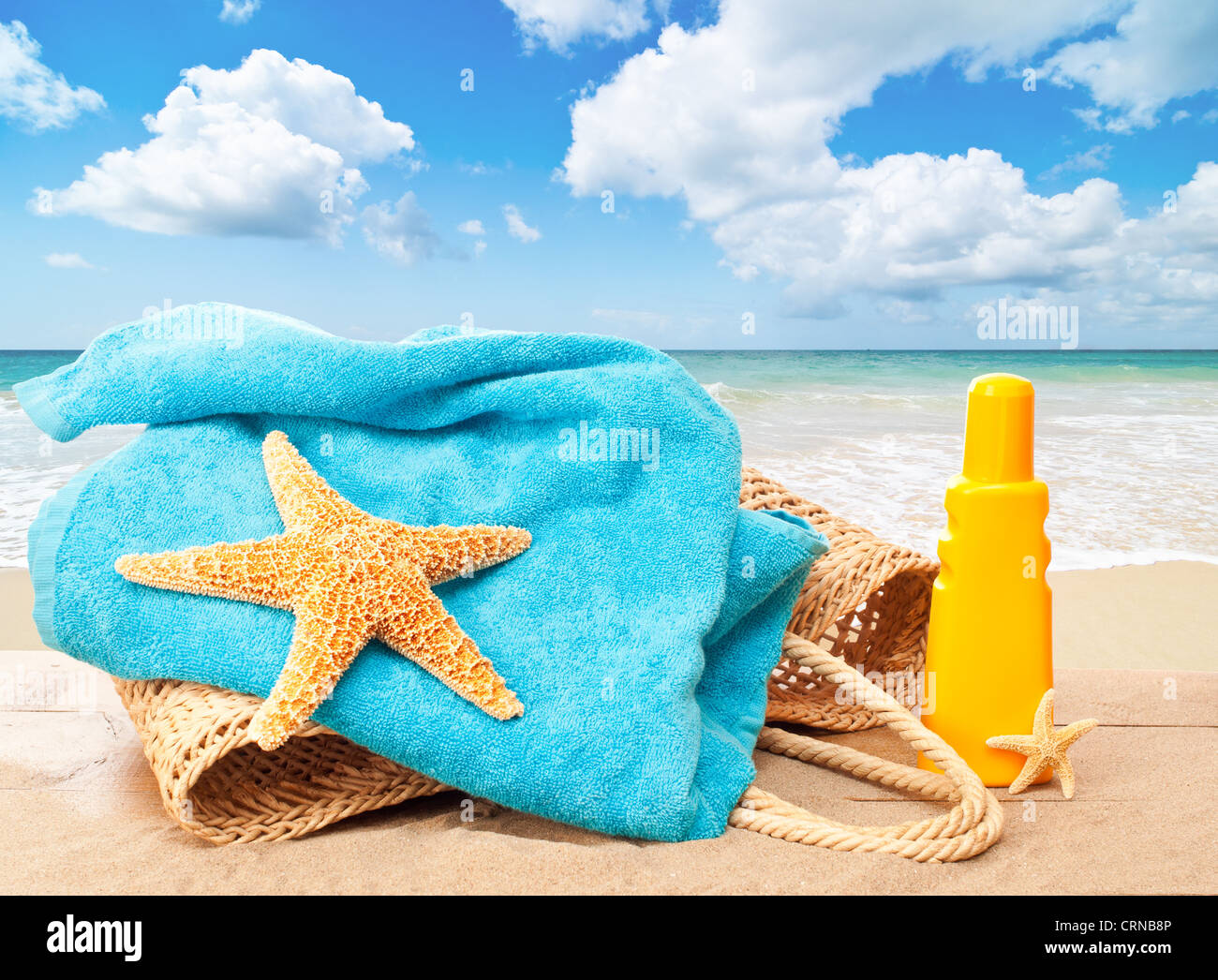 Holiday beach basket with towel and sun tan lotion overlooking an