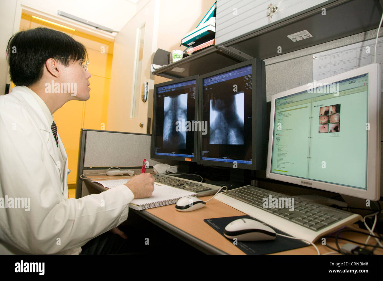 A doctor views x-ray images, as part of patient diagnosis, in the Reading Room, Samsung Medical Centre, South Korea. Stock Photo