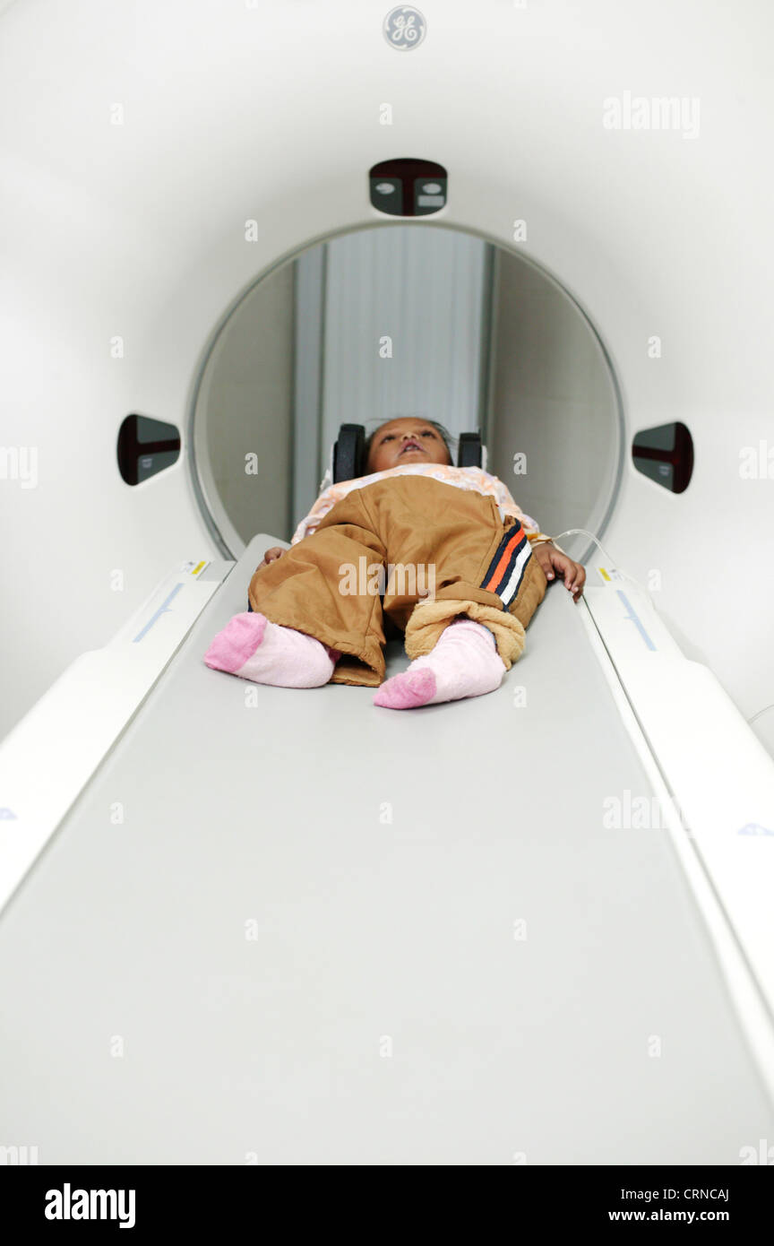 A 5 year old child lays still for a CT (Computer Tomography) scan of her brain. Stock Photo