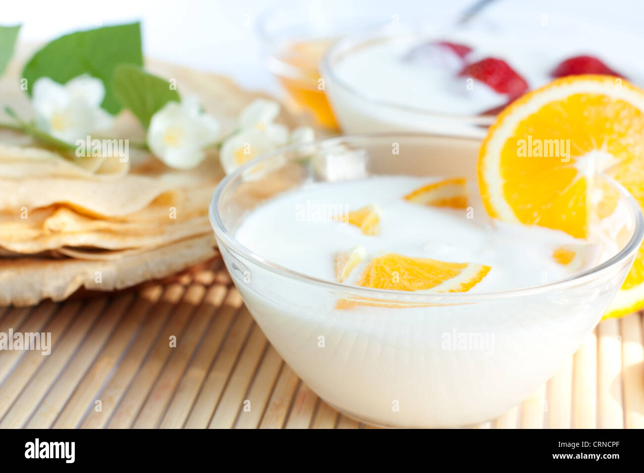 Orange Yogurt and golden pancakes. Luncheon Stock Photo