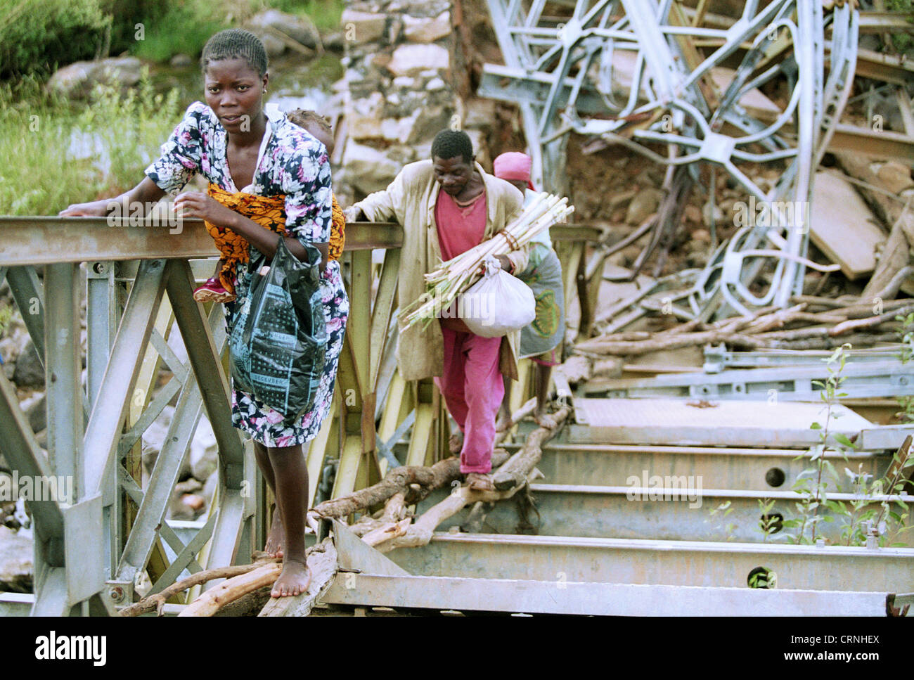 Women cross a bridge was destroyed, Angola. Stock Photo