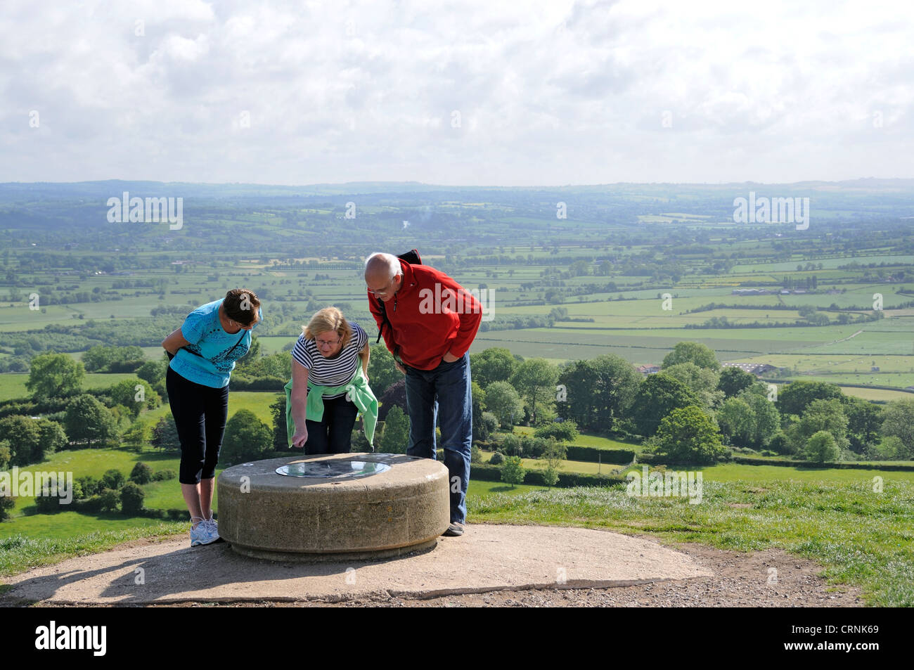 Tourists looking at the viewfinder map on the summit of Glastonbury Tor. Stock Photo
