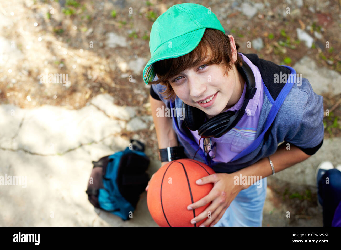 The above view of a smiling teen boy holding a basket-ball Stock Photo