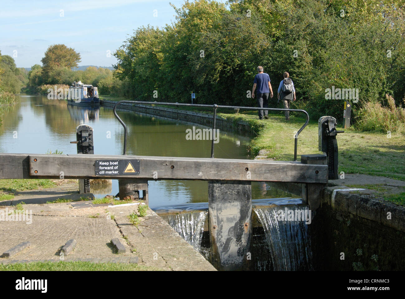 Canal lockgate and towpath with walkers, Aylesbury Arm, Grand Union Canal, near Puttenham, Hertfordshire, England, september Stock Photo