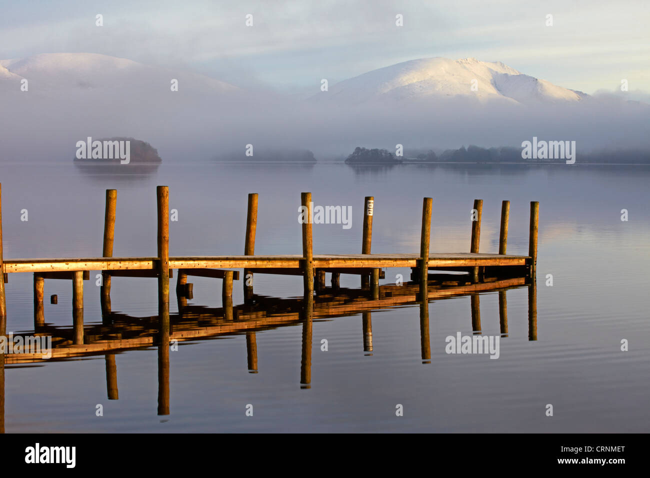 Snow covered Blencathra reflected in Derwentwater from Brandelhow jetty. Stock Photo