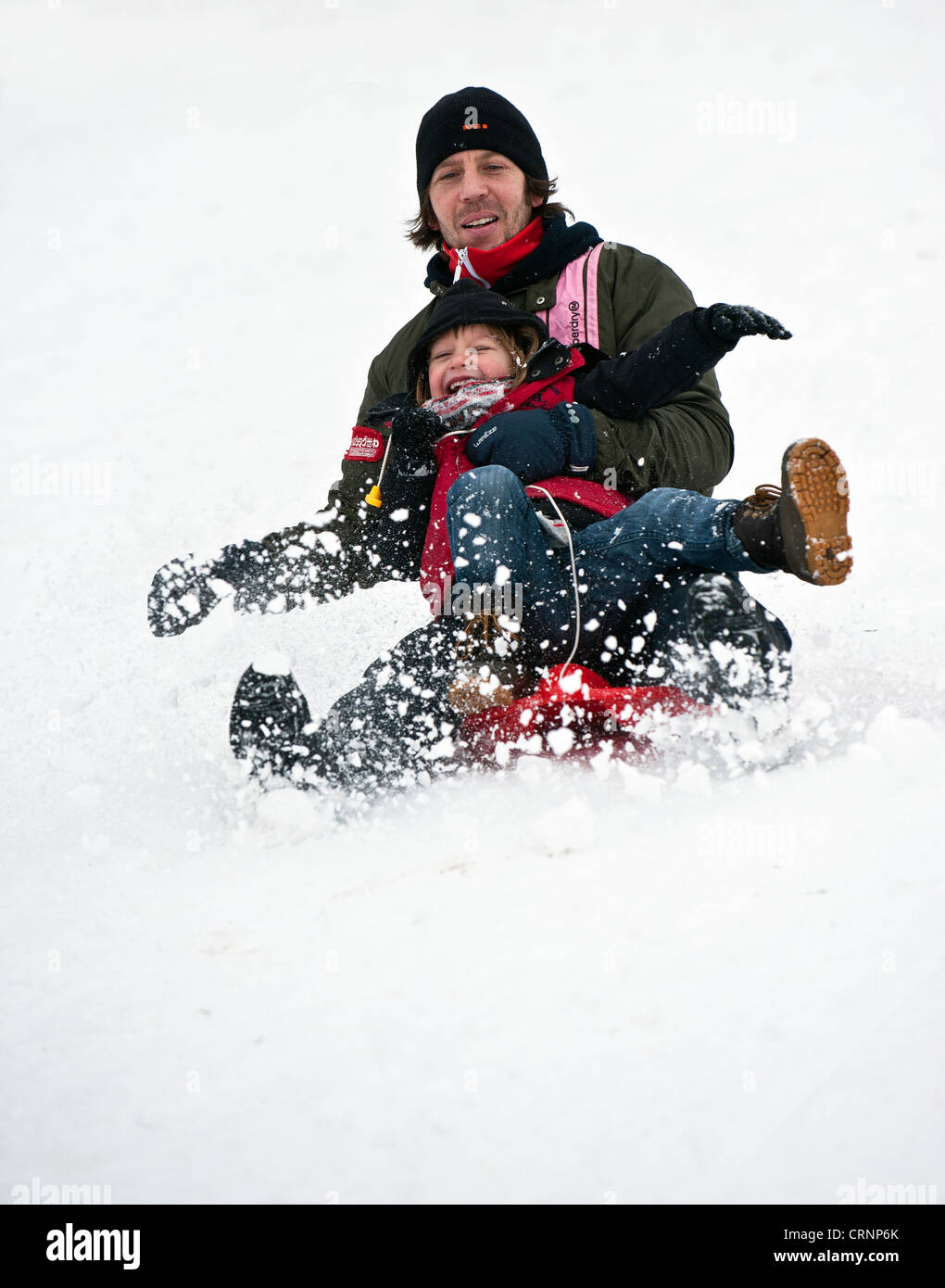 Father and child tobogganing in the snow Stock Photo Alamy