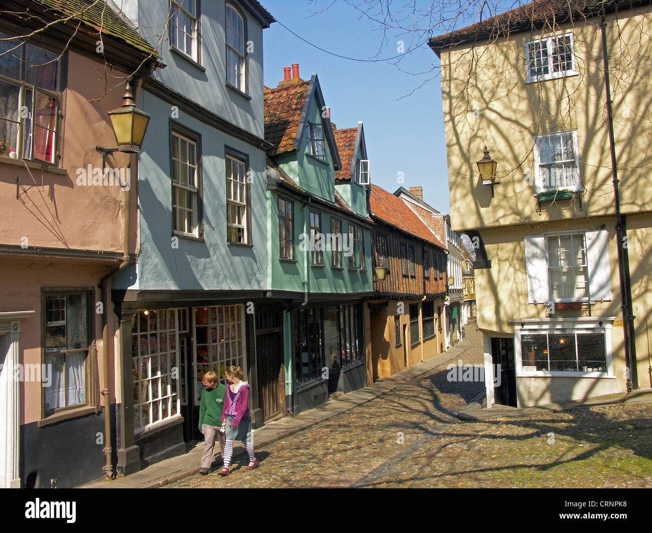 Couple walking on the cobbles of Elm Hill by colourful Tudor timber-framed buildings. Stock Photo