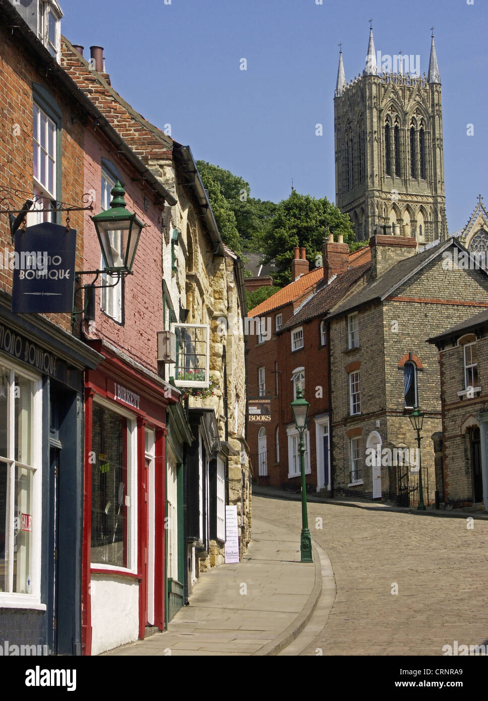 Medieval buildings line the cobbled street and flagstoned pavement leading to the cathedral quarter at the top of Steep Hill in Stock Photo