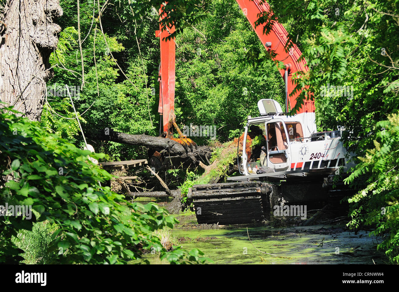 Crane clearing channel debris from an overgrown canal off the Fox River